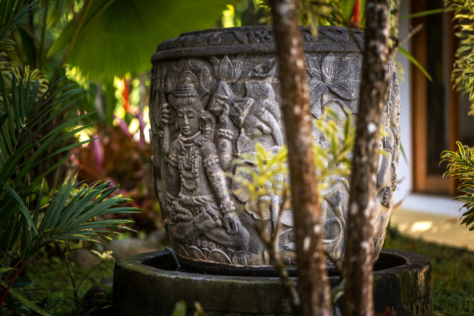 Carved stone sculpture in tropical garden