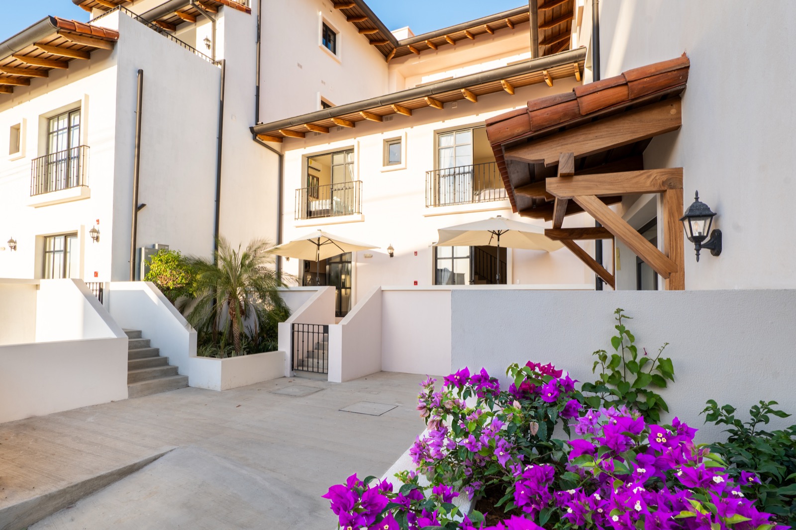 White villa exterior with stairway and flowers