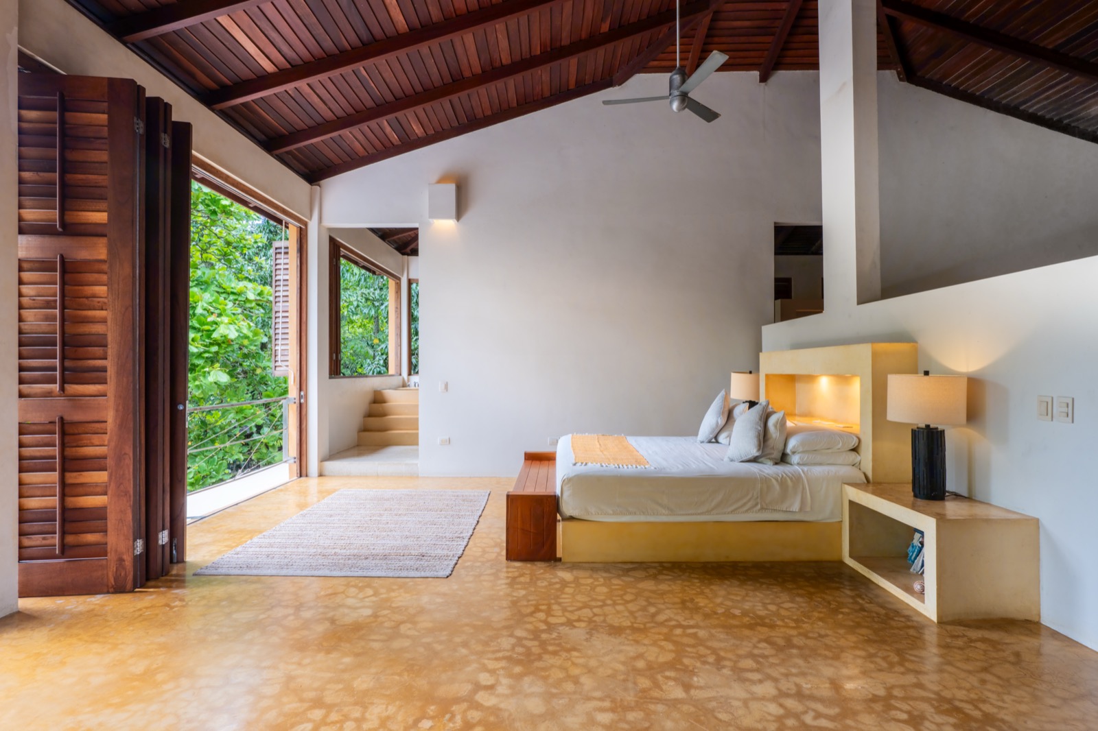 Spacious bedroom with wood ceiling and garden shutters
