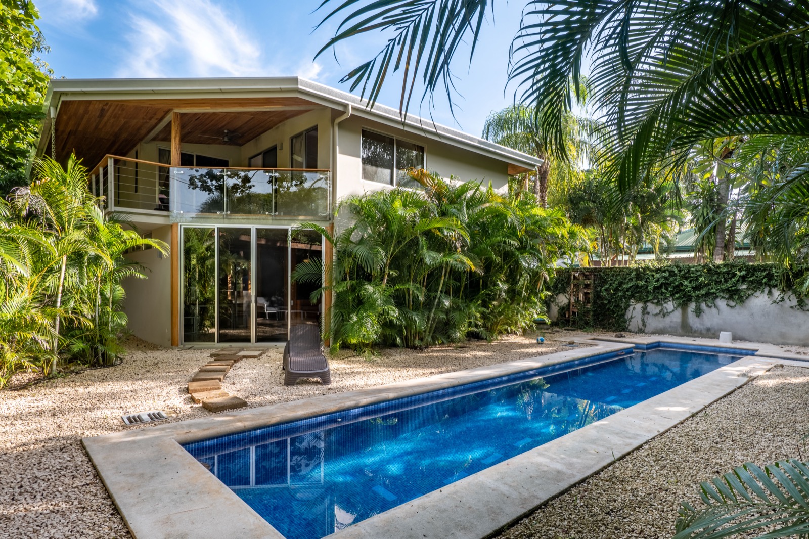 Modern villa with pool surrounded by palm trees
