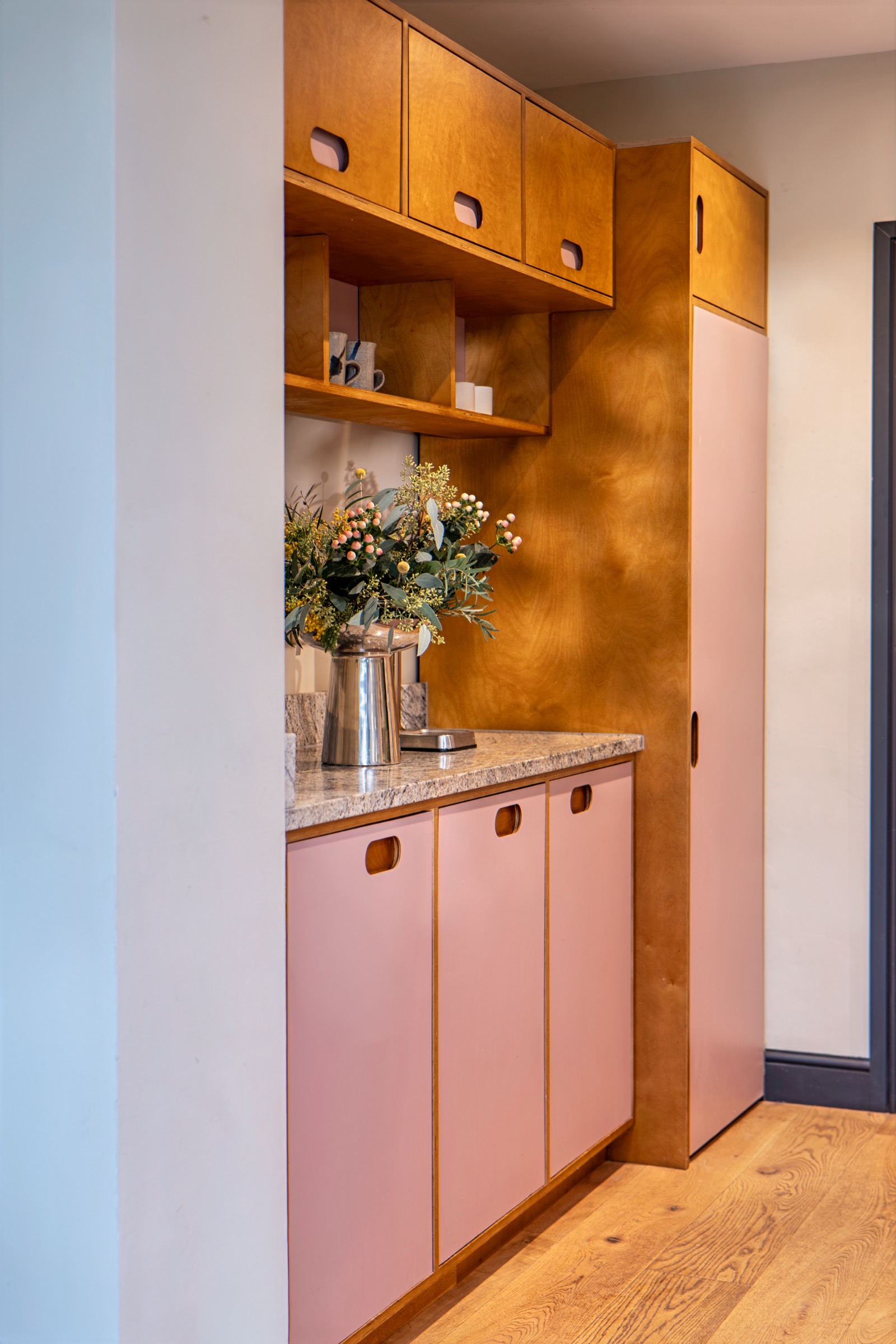 Charming kitchen nook with pink cabinets and flowers