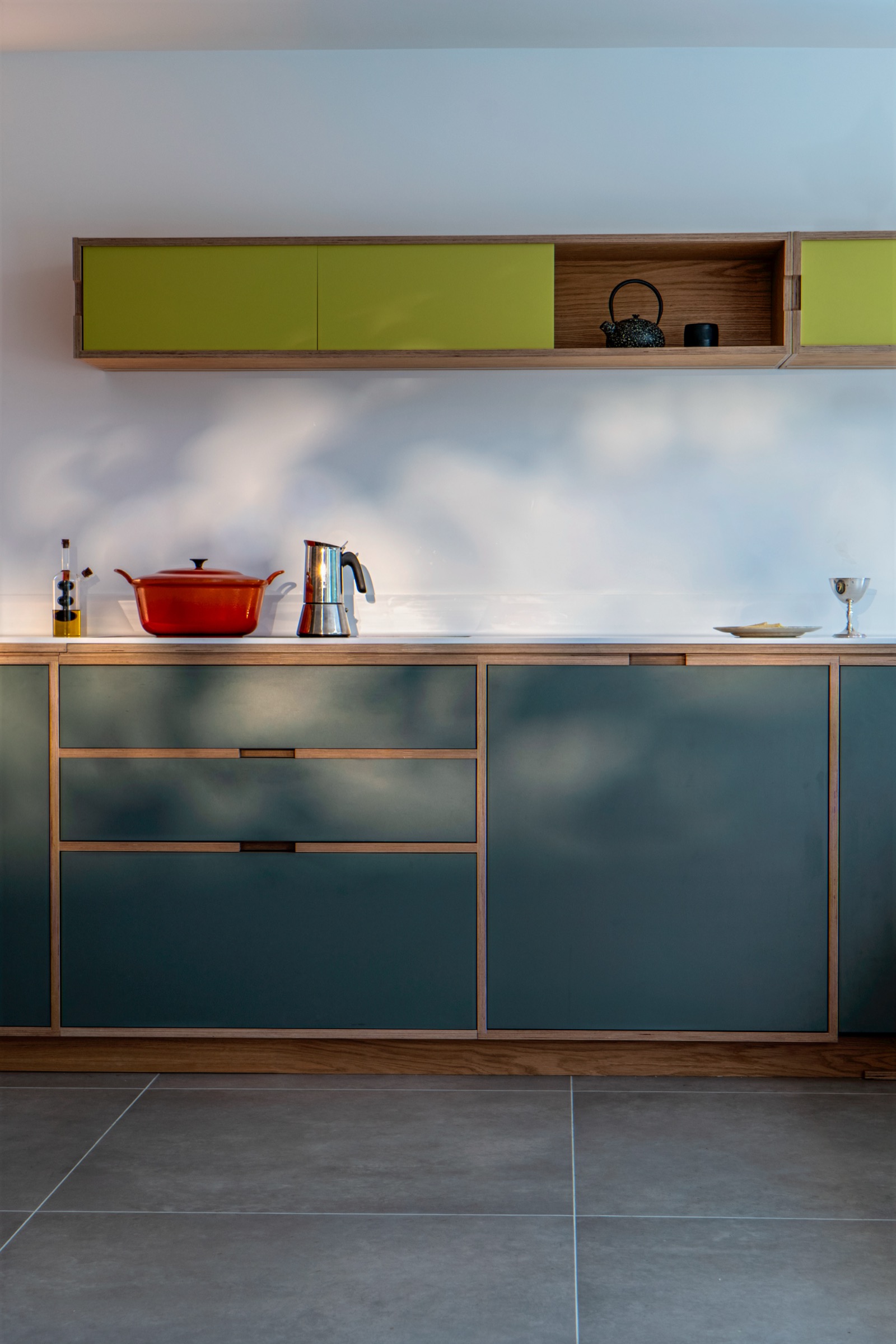 Designer kitchen with teal cabinets and green accents